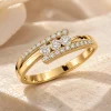 Bague Harmonie en or jaune 18 carats, trois diamants ronds au centre et monture croisée diamantée.